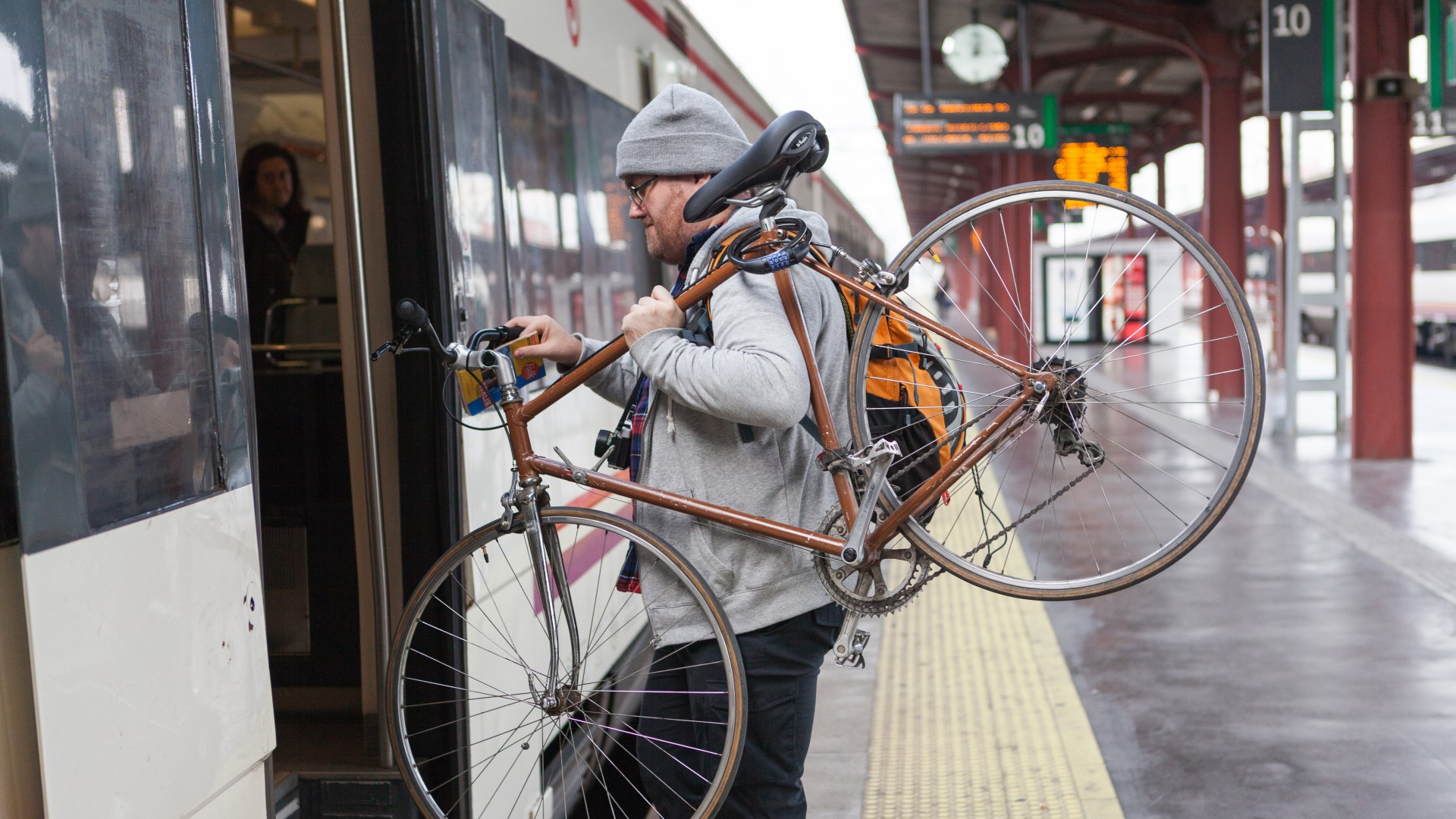 Mand med cykel på vej ind i tog